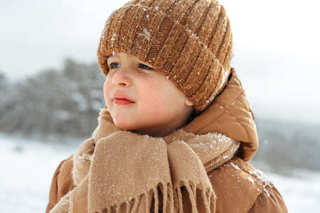 Little boy in a winter park or forest
