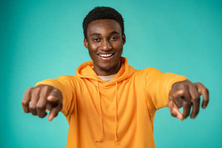 Young african american man wearing casual clothes pointing to youの写真素材