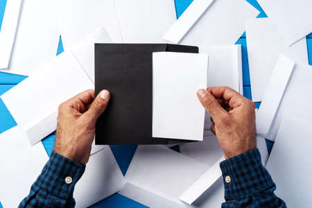 Business correspondence. Top view of man hands holding mockup envelope with letter. Copy space.の写真素材