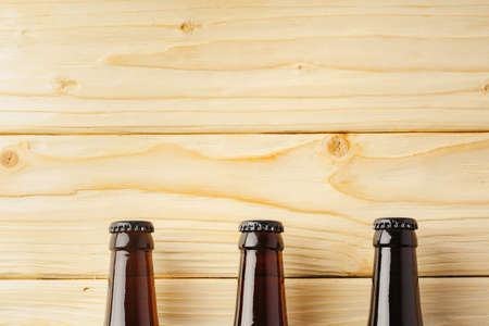 Beer bottle on a brown wooden table flat lay background with a copy space