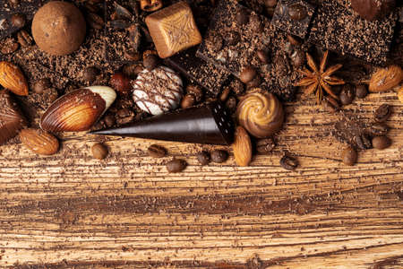 chocolate, cocoa, nuts and spices on wooden background