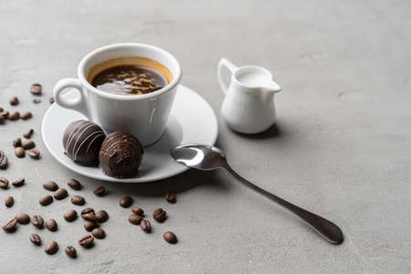 Coffee cup and sweet candy on gray tableの写真素材