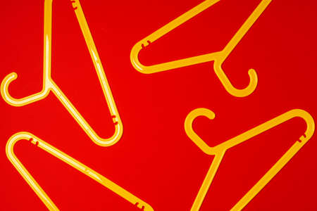 Hanger on red paper background. Minimalistic fashion concept. Top viewの写真素材