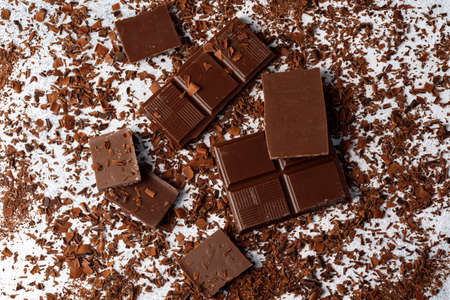 Grated chocolate and pieces of tasty chocolate on tableの写真素材