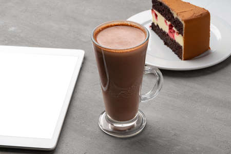 Chocolate cake with cup of cocoa on tableの写真素材