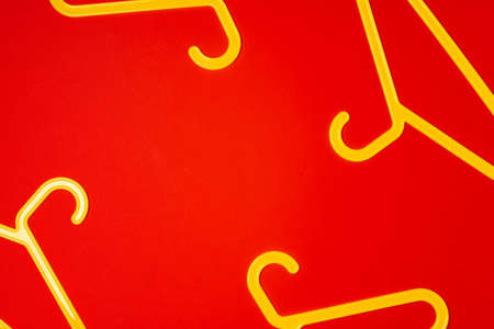 Hanger on red paper background. Minimalistic fashion concept. Top viewの写真素材