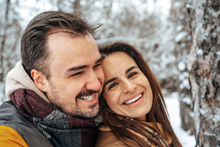 Young couple in love outdoor in snowy winter forest.