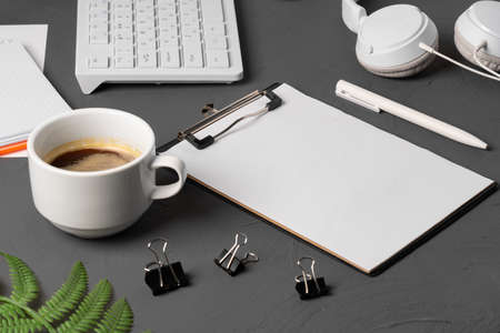 Clipboard mock up on home office workspace with coffee cup and stationery