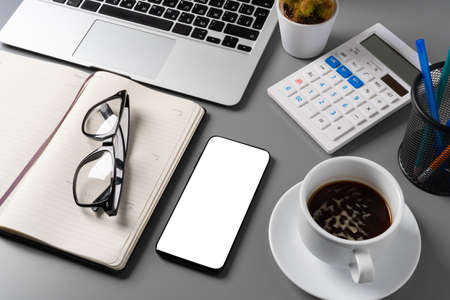 Notepad is on top of office desk table with laptop and supplies
