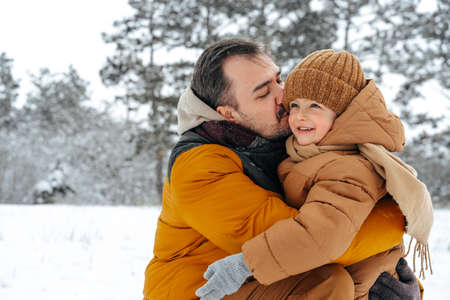 Father and son playing in the park on winter day