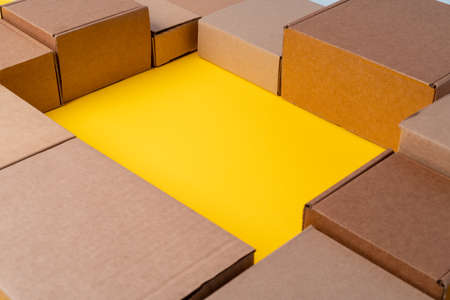 Beige cardboard boxes on yellow background, close upの写真素材