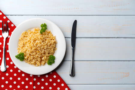 Cooked bulgur in a plate on a wooden background top viewの写真素材