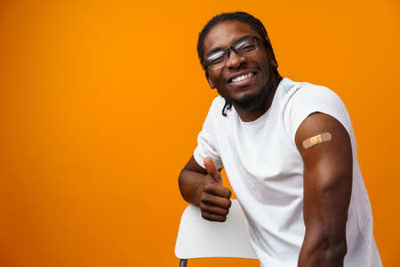 Young black man got vaccinated from virus against yellow background