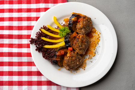 Cooked meat with fresh vegetable salad on a white plateの写真素材