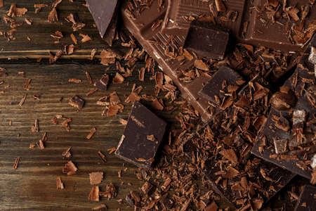 Grated chocolate and pieces of tasty chocolate on table