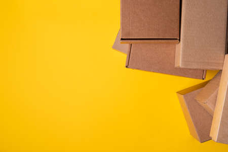Beige cardboard boxes on yellow background, close upの写真素材