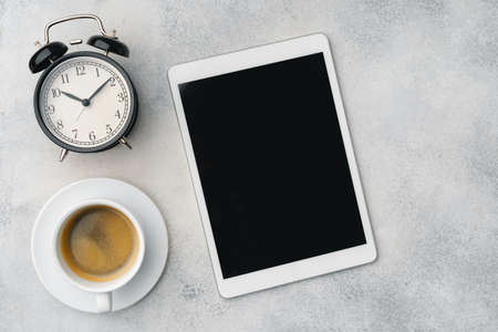 Digital tablet and coffee cup on gray tableの写真素材
