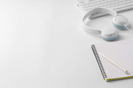 Minimalistic white workplace with keyboard and notebookの写真素材