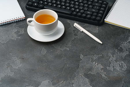 Office desk with computer keyboard, notepad and pen