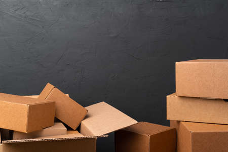 Stack of cardboard boxes against black backgroundの写真素材