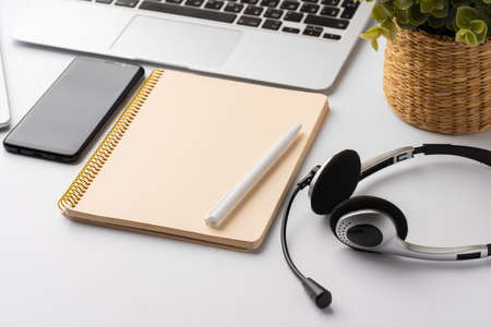 Minimalistic white workplace with keyboard and notebookの写真素材