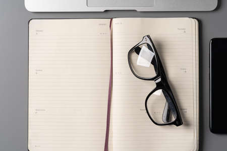 Office desk with notepad, glasses and supplies