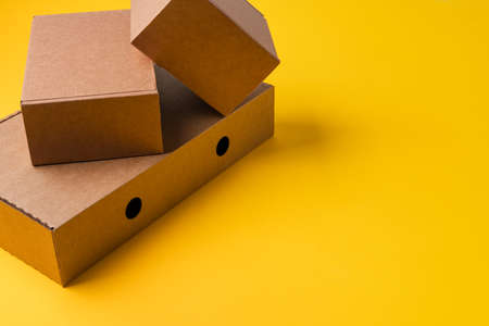 Beige cardboard boxes on yellow background, close upの写真素材