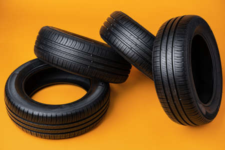 Car tires isolated on yellow background, close up