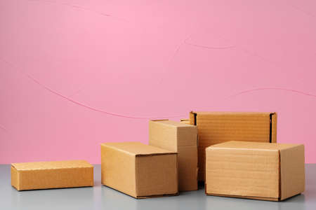 Set of cardboard boxes on pink background