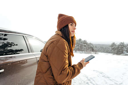 Woman in winter warm jacket walking in snowy winter forest