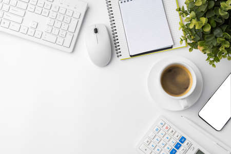Office desk with laptop, blank notebook and coffee cupの写真素材