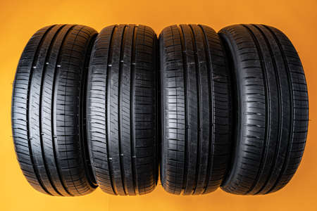 Car tires isolated on yellow background, close upの写真素材