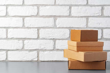 Cardboard boxes against white brick wall, close up