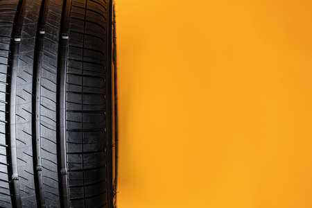 Car tires isolated on yellow background, close upの写真素材