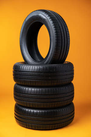 Car tires isolated on yellow background, close upの写真素材