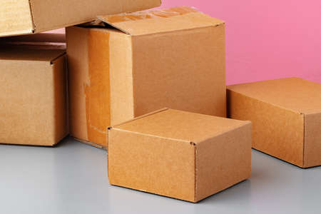 Set of cardboard boxes on pink background