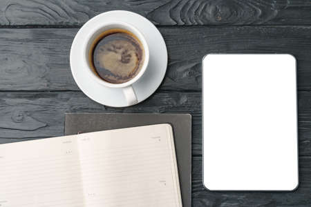 Digital tablet and coffee cup on gray table