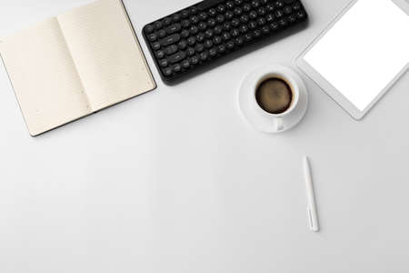 Minimalistic white workplace with keyboard and notebook