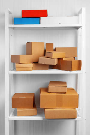 Stack of cardboard package boxes on wooden rackの写真素材
