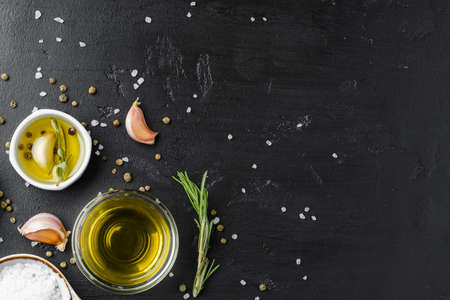 Olive oil, herbs and spices on black backgroundの写真素材
