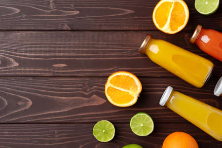 Fruit drink in glass bottle and frsh fruits on wooden backgroundの写真素材