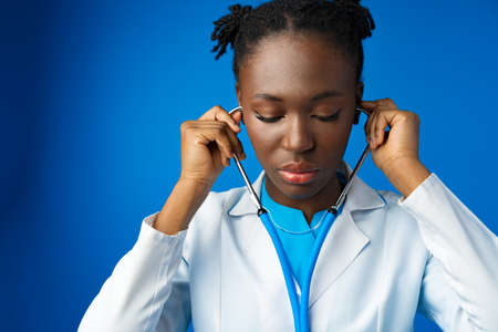 Portrait of young african female doctor in blue studioの写真素材