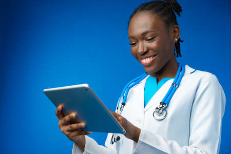 Portrait of an African American female doctor holding a tablet for work in studioの写真素材