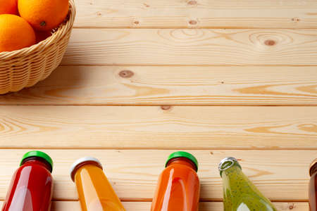 Different bottles of juice on wooden tableの写真素材