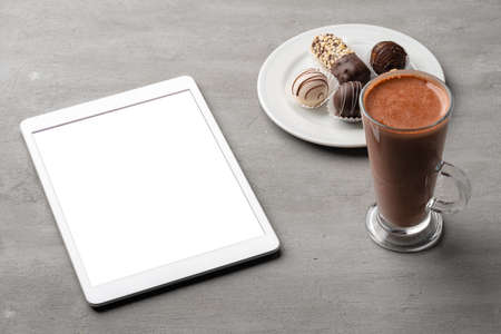 Coffee cup and sweet candy on gray tableの写真素材