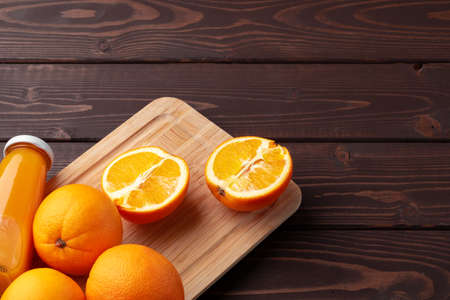 Glass of fresh orange juice with fresh fruits on wooden tableの写真素材