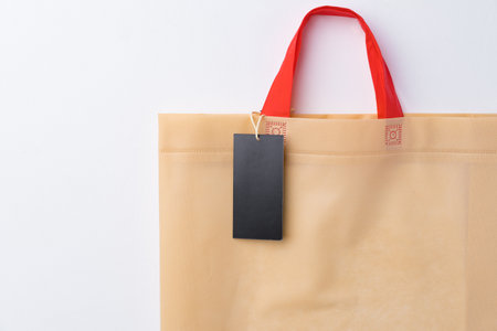 Blank paper tag with shopper paperbag on white backgroundの写真素材