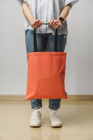 Cropped image of woman holding color shopping bag in studio