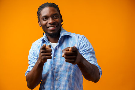 Young african american man wearing casual clothes pointing to youの写真素材
