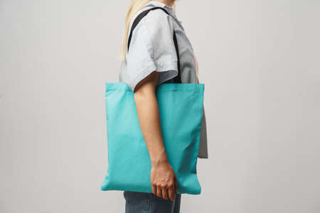 Cropped image of woman holding color shopping bag in studioの写真素材